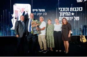 הרב יצחק דור מקבל תעודת ההוקרה מאביו של יוסי הרשקוביץ ז״ל