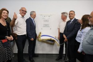 ראש העיר משה ליאון ואריק גרבלסקי מסירים את הלוט מעל לוח ההקדשה של סניף תנועת עזרא בקריית מנחם